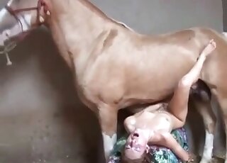 Skinny hottie fucks with a horse in a missionary pose and moans